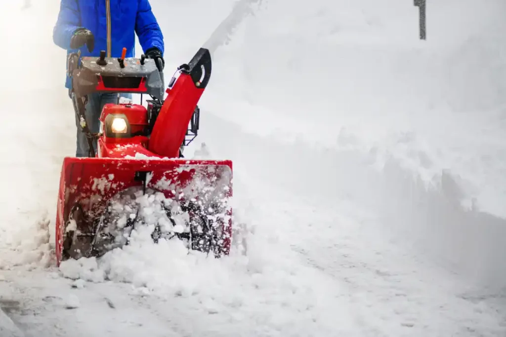 Summer and winter preparations for houses in Sweden a person on a snow blower